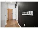 Hallway with light wood floors, contrasting paint, and a unique piano key art installation on the wall at 891 14Th St # 2105, Denver, CO 80202