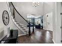 Grand foyer showcasing a curved staircase, hardwood floors, and a view into the living room at 11522 Trona Ct, Parker, CO 80138