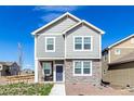 Attractive home with light gray siding, white trim, and stone accents on the facade at 803 N Bently St, Watkins, CO 80137