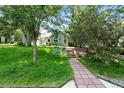 Charming home with a red brick walkway, mature trees, and a lush lawn at 1451 S Columbine St, Denver, CO 80210