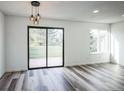Bright living room with new floors, modern lighting, a large window, and a glass patio door at 956 S Peoria St, Aurora, CO 80012