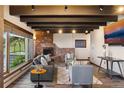 Cozy living room with exposed beams, brick fireplace, and stylish contemporary furnishings at 3021 N Lakeridge Trl, Boulder, CO 80302