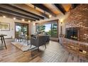 Charming living room featuring a brick fireplace, exposed wood beams, and abundant natural light at 3021 N Lakeridge Trl, Boulder, CO 80302