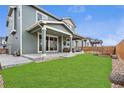 Spacious backyard with lush green lawn and covered patio, perfect for entertaining at 18077 E 99Th Ave, Commerce City, CO 80022