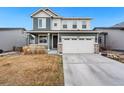 Inviting two-story home with a well-maintained lawn, a two-car garage, and charming architectural details at 18077 E 99Th Ave, Commerce City, CO 80022