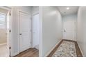 Bright hallway with wood floors, neutral walls, and a patterned rug leads to various rooms at 8517 Eckley St, Littleton, CO 80125