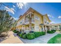 Charming yellow two-story townhome exterior with well-kept landscaping and inviting front porches on both floors at 9585 Pearl Cir # 203, Parker, CO 80134