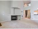 Open-concept living room with a fireplace, staircase, and access to other areas of the home at 5155 W Quincy Ave # J103, Denver, CO 80236
