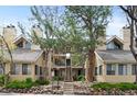 Multi-level condominium featuring lush trees and stone landscaping at 4824 E Kentucky Ave # F, Denver, CO 80246