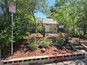 View of the front yard and exterior of the home, surrounded by trees and a chain-link fence at 1272 N Ulster St, Denver, CO 80220