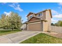 Charming home exterior featuring a two-car garage, lush lawn, and mature flowering tree at 5452 Rustic Ave, Firestone, CO 80504