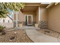 Welcoming front porch with decorative planters and a stone walkway to the front door at 5452 Rustic Ave, Firestone, CO 80504