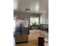 Functional kitchen with a stainless steel refrigerator and white cabinets at 11502 E 7Th E Ave, Aurora, CO 80010