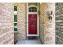 Inviting front entrance with a red door, brick surround, and a welcoming 'hello' doormat at 16863 Trail View Cir, Parker, CO 80134
