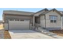 Inviting home with a two-car garage, stone details, and a welcoming entrance at 22036 E 39Th Pl, Aurora, CO 80019