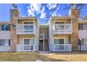 Stylish condo exterior features stone accents, white railings, and stairs leading to upper-level units at 14473 E Jewell Ave # 202, Aurora, CO 80012