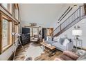 Cozy living room with wood accents, a staircase, and a large window providing ample natural light and scenic views at 538 Sawmill Creek Rd, Evergreen, CO 80439