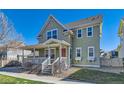 Charming home boasts a cozy front porch, neat landscaping, and a vibrant red door, all under a clear blue sky at 9435 E 108Th Pl, Commerce City, CO 80640