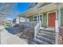 Inviting front porch with white railings, decorative details, and a colorful wreath on the front door at 9435 E 108Th Pl, Commerce City, CO 80640