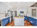 Modern kitchen features white and blue cabinets, hardwood floors and a center island at 6982 Mountain Brush Cir, Highlands Ranch, CO 80130