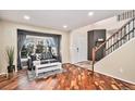Bright living room with hardwood floors, staircase, and large window at 6982 Mountain Brush Cir, Highlands Ranch, CO 80130