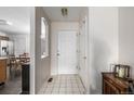 Bright entryway featuring tile floors, a front door, coat closet, and adjacent dining area with natural light at 2860 Calkins Pl, Broomfield, CO 80020
