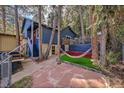 Cozy backyard featuring a hammock and a stone patio, perfect for relaxation at 26378 S End Rd, Kittredge, CO 80457
