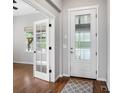 Elegant foyer with hardwood floors, white trim, a front door featuring decorative glass and a nearby room behind french doors at 4421 Tanager Trl, Broomfield, CO 80023