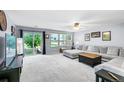 Spacious living room featuring a large sectional sofa, and a sliding glass door that opens to the backyard at 351 Montgomery Dr, Erie, CO 80516