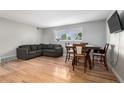 Open-concept living and dining area featuring hardwood floors and bright natural light at 12131 Melody Dr # 101, Denver, CO 80234