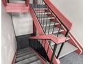 Interior staircase featuring gray carpet and red and black railings at 12131 Melody Dr # 101, Denver, CO 80234