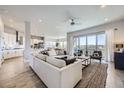 Open-concept living room with modern furnishings, hardwood floors, and sliding doors to a balcony at 9559 Yucca Way, Arvada, CO 80007