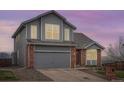 Charming two-story home featuring a brick and gray wood exterior with a two-car garage at 16645 W 2Nd Ave, Golden, CO 80401