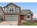Charming two-story home featuring a brick and gray wood exterior with a two-car garage at 16645 W 2Nd Ave, Golden, CO 80401