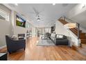 Cozy living area with a modern fireplace, mounted TV, hardwood floors, and an open layout to the kitchen and dining at 3845 N Raleigh St, Denver, CO 80212