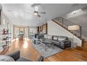 Open-concept living room with hardwood floors, modern staircase, and seamless flow to dining area and kitchen at 3845 N Raleigh St, Denver, CO 80212