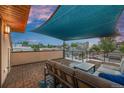 Rooftop deck with shade covering, modern outdoor furniture, and a view of the surrounding neighborhood at 3845 N Raleigh St, Denver, CO 80212