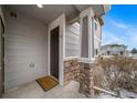 Charming front entrance with stone pillar, neutral siding, and a dark-colored door, creating a welcoming first impression at 17127 Lark Water Ln # D, Parker, CO 80134