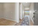 Inviting foyer featuring neutral walls, sleek wood-look floors, decorative rugs, and views into the living area at 6070 Long Branch Dr, Parker, CO 80134