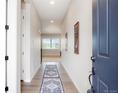 Inviting hallway features wood floors, soft natural light and flows to other rooms in the home at 6070 Long Branch Dr, Parker, CO 80134