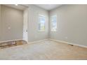 Bright living room with neutral walls and carpet, two windows providing ample natural light, and wood-look flooring at 6070 Long Branch Dr, Parker, CO 80134