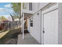 Exterior unit entrance with white door and siding, next to lawn and fence at 4670 W Nevada Pl # A, Denver, CO 80219