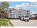 Townhouse featuring a gray exterior and balconies, with parking in front at 4670 W Nevada Pl # A, Denver, CO 80219