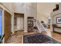 Grand foyer with hardwood floors, a staircase, and a view into the living room at 20510 Oakbrook Ln, Parker, CO 80138