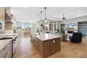 Spacious kitchen with island and breakfast bar opening up to the living room and dining area at 32 Latigo Pl, Littleton, CO 80123