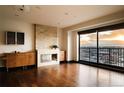 Open-concept living area featuring wood floors, a stone fireplace, and balcony access with city views at 1133 14Th St # 2110, Denver, CO 80202
