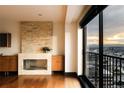 Bright living room featuring a stone fireplace, wood floors, and balcony with city views at 1133 14Th St # 2110, Denver, CO 80202