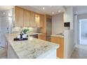 Modern kitchen with granite counters and wood cabinets at 1313 N Williams St # 1103, Denver, CO 80218