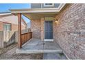 Inviting front porch with brick accents and wooden railings, offering a warm welcome to the home at 12144 Newport Dr, Brighton, CO 80602