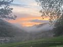 Stunning sunset view over misty mountains and lush, green hillside at 20 W Ranch Trl, Morrison, CO 80465